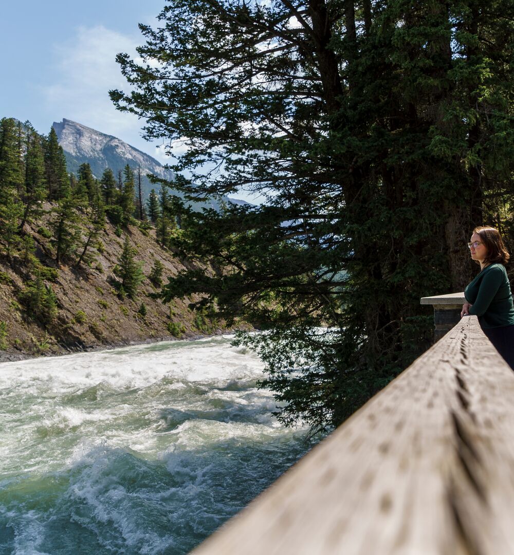 A person taking a break on the Bow River Trail on the way to Bow Falls