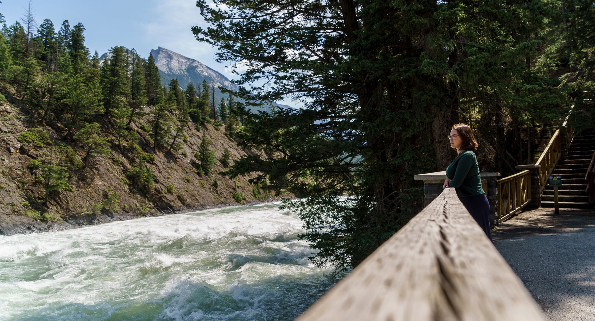 A person taking a break on the Bow River Trail on the way to Bow Falls
