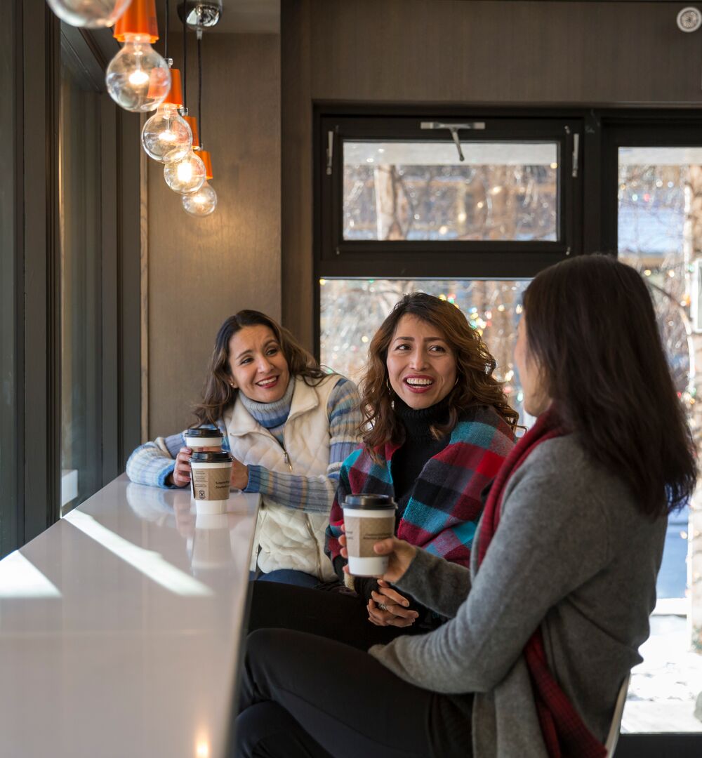 Three girls enjoying coffee at the Whitebark Cafe in Banff.