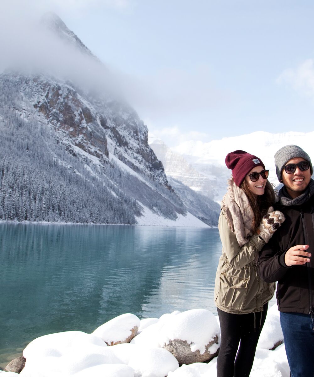 A couple takes a selfie at Lake Louise on a snowy winter day in Banff National Park