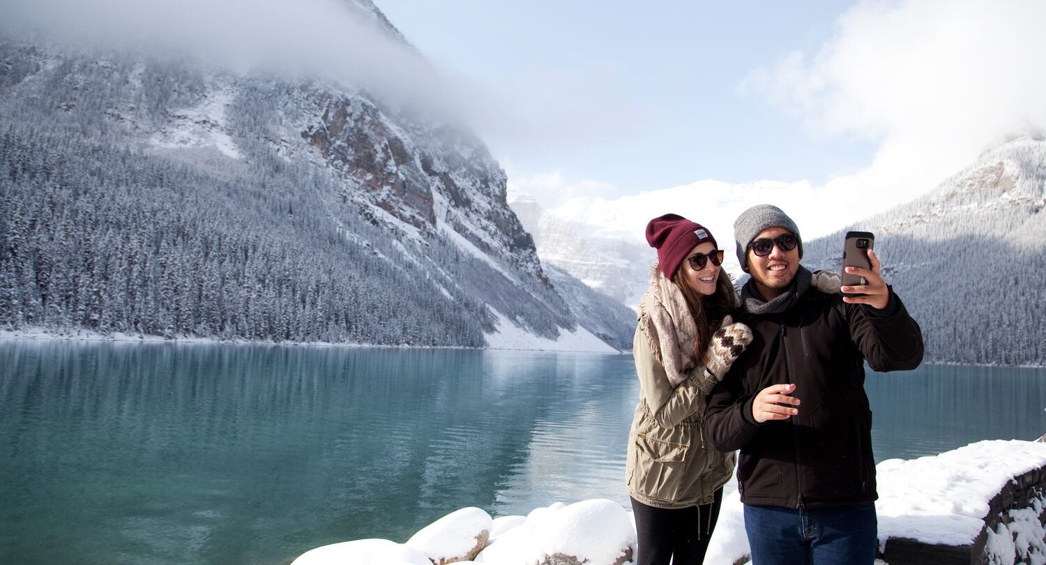 A couple takes a selfie at Lake Louise on a snowy winter day in Banff National Park