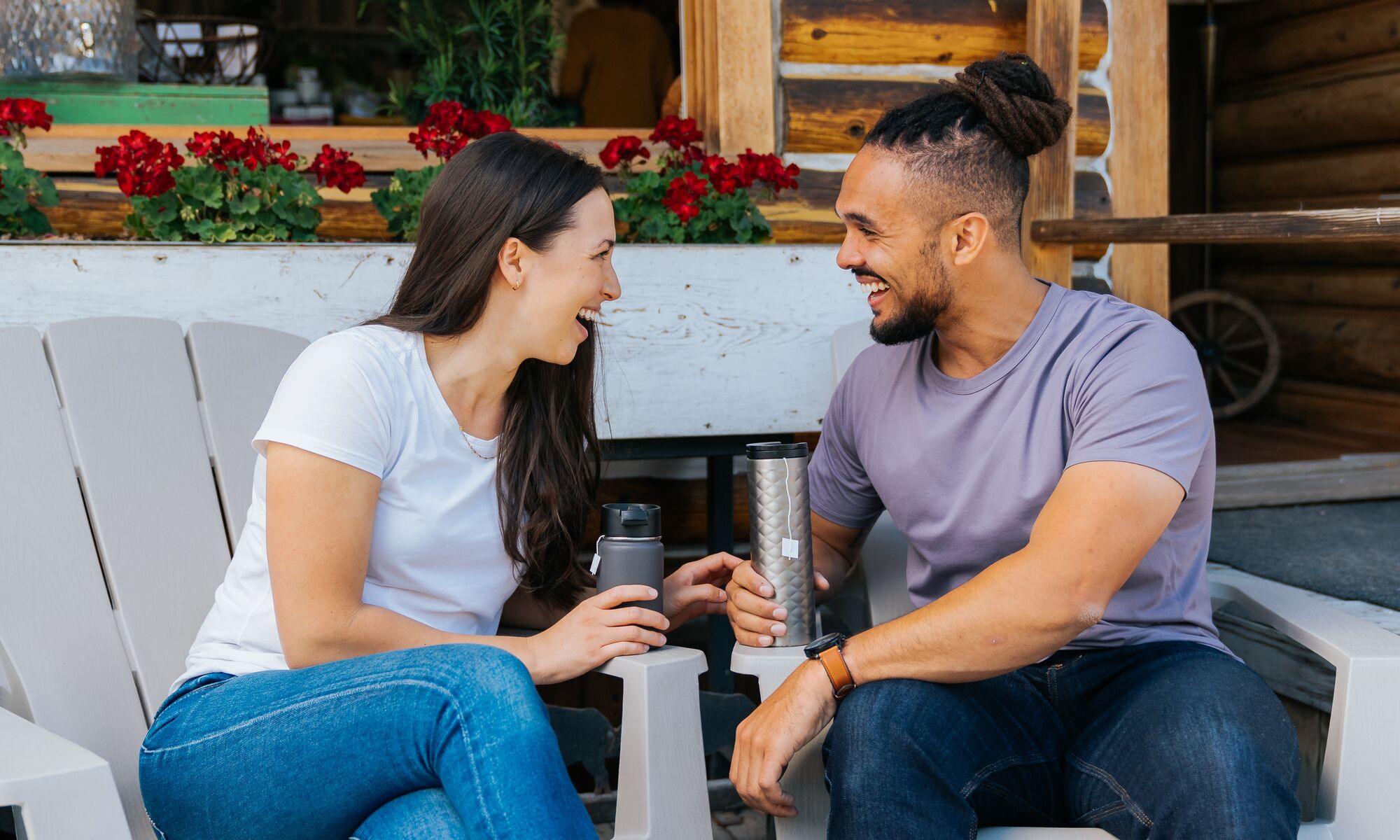 Two people sit in chairs with reusable mugs on Bear Street in Banff National Park.