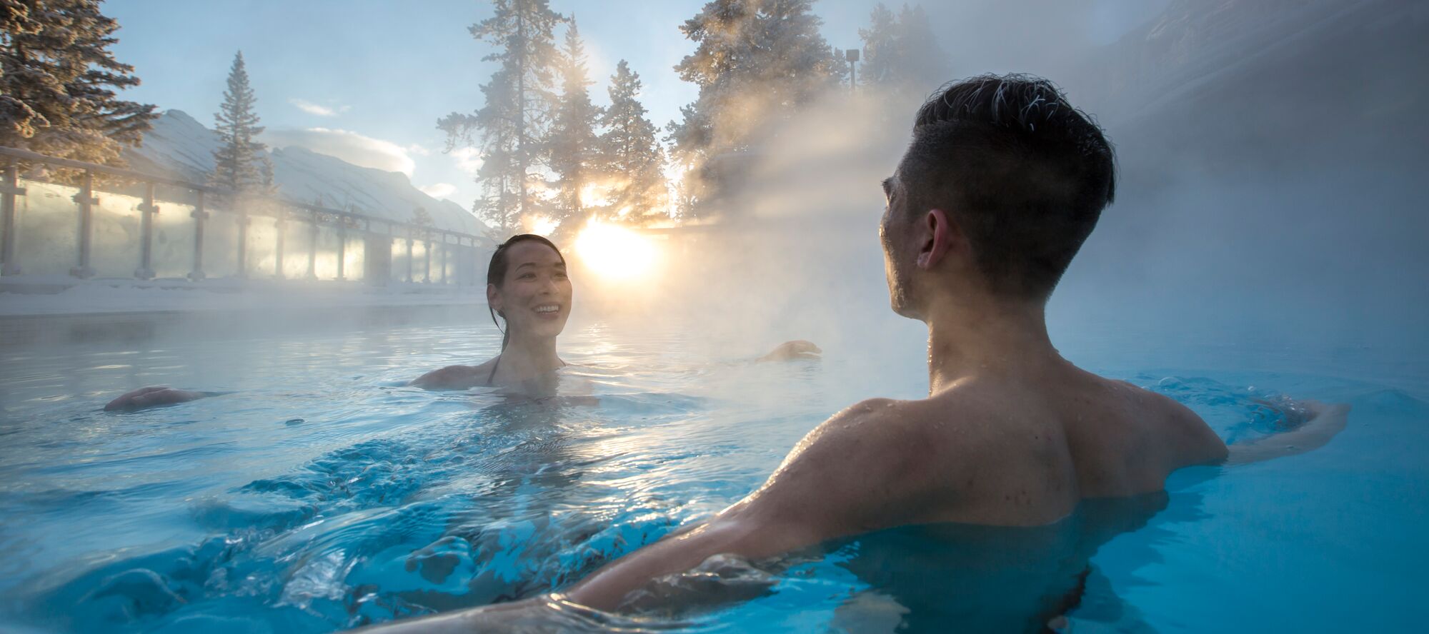 A couple sits in the Upper Hot Springs in Banff National Park on a frosty winter day
