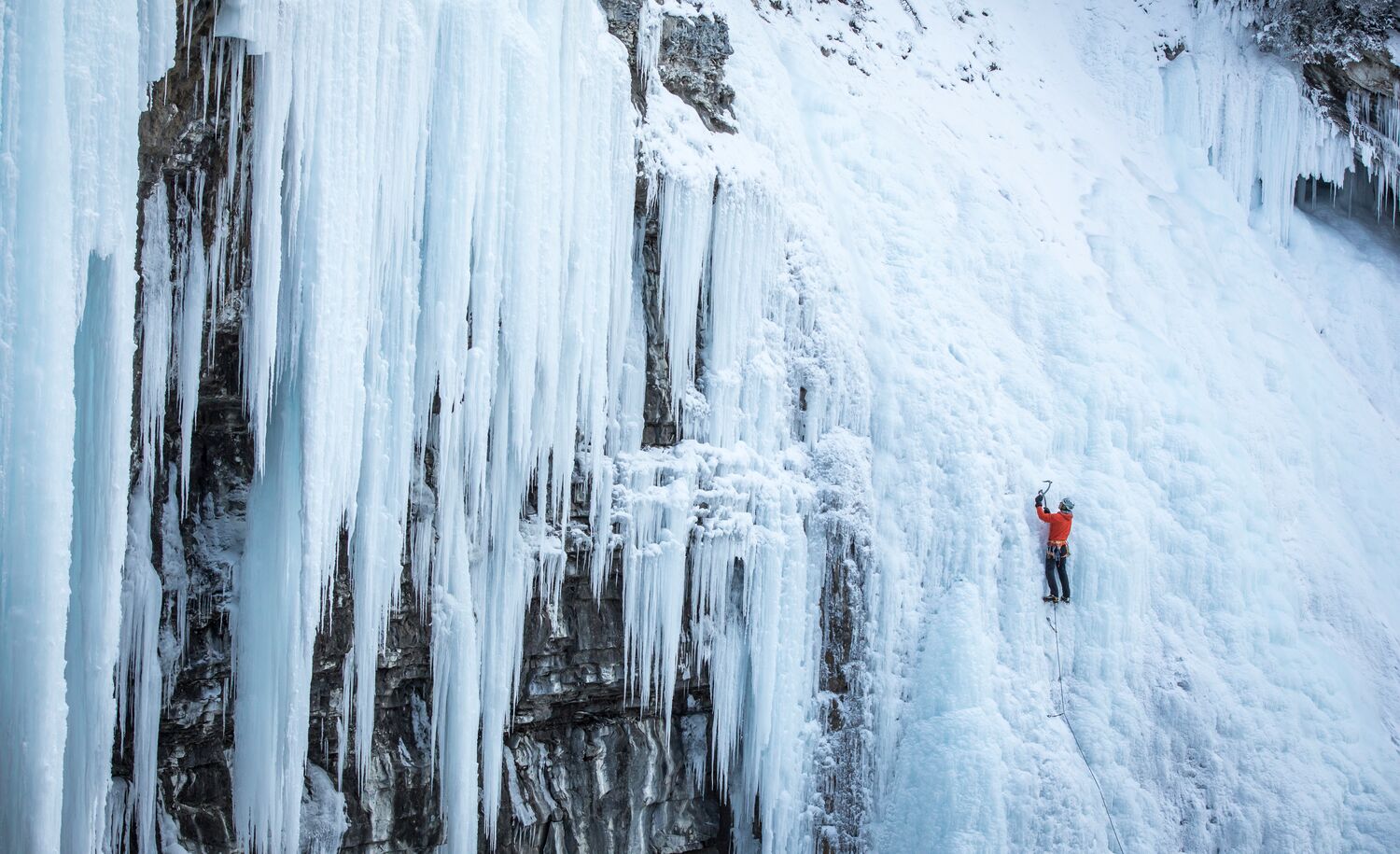 An Ice climber climbs up the frozen waterfall in Johnston Canyon on a crisp winter day.