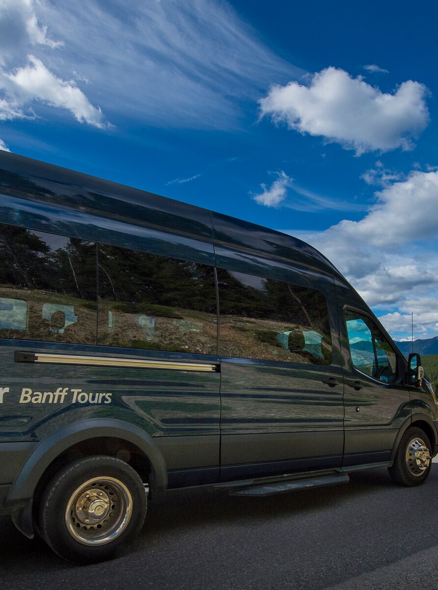 Discover Banff Tours bus on a bluebird day in Banff National Park.