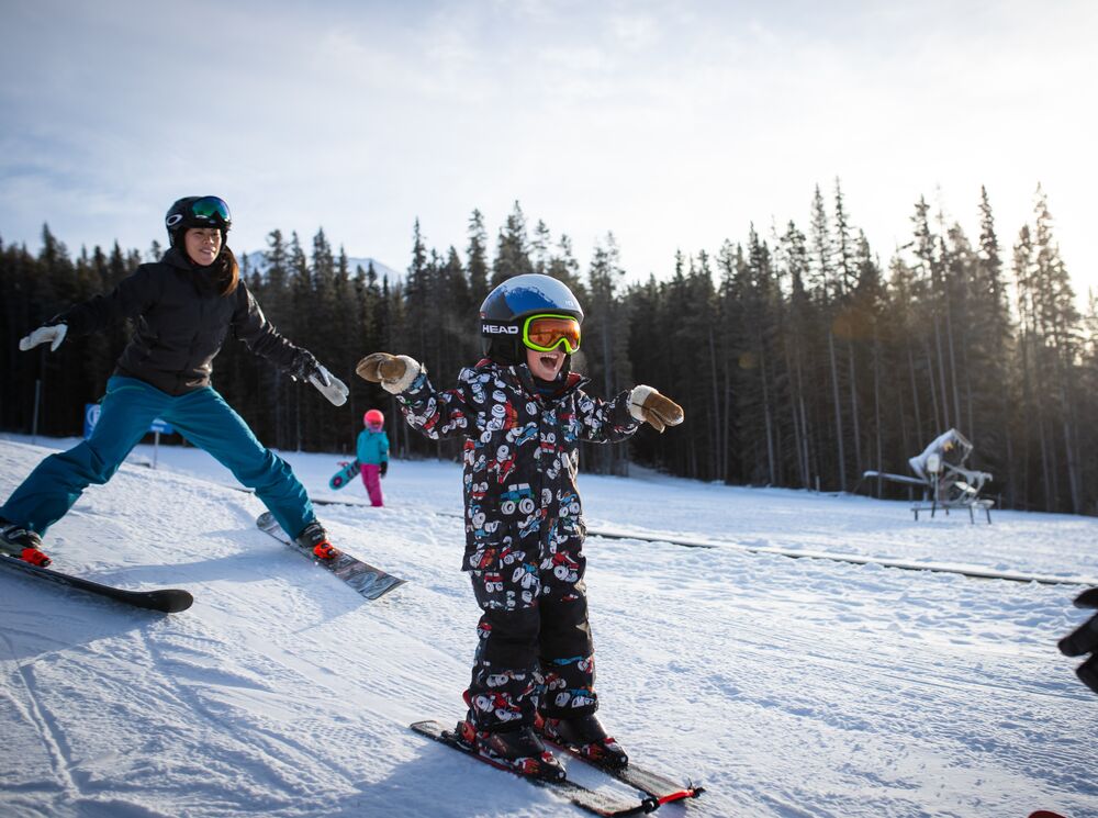 A child learning how to ski with an instructor at Lake Louise ski resort in Banff National Park