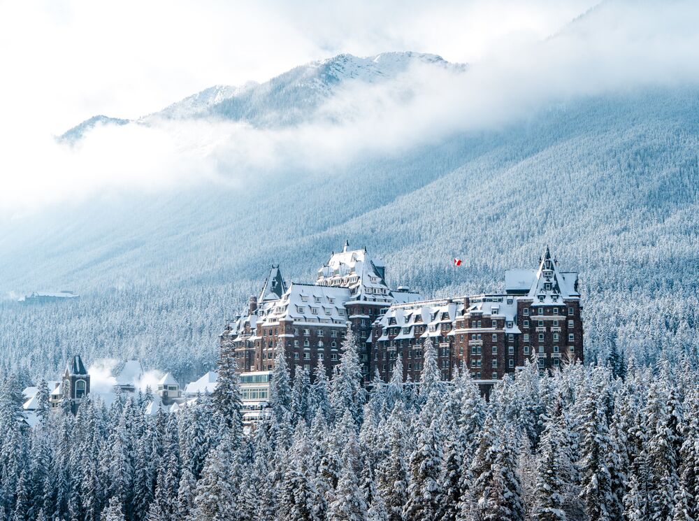 The Fairmont Banff Springs Hotel rises from snowy trees in Banff National Park.