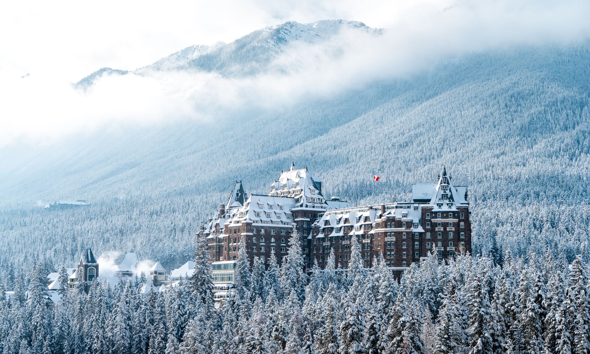 The Fairmont Banff Springs Hotel rises from snowy trees in Banff National Park.