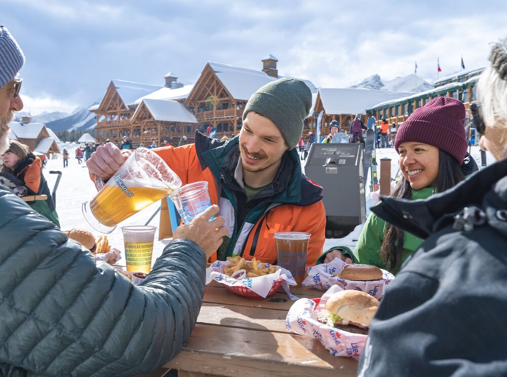 Two Couples having a drink on a patio at the Lake Louise Ski Resort in Banff National Park