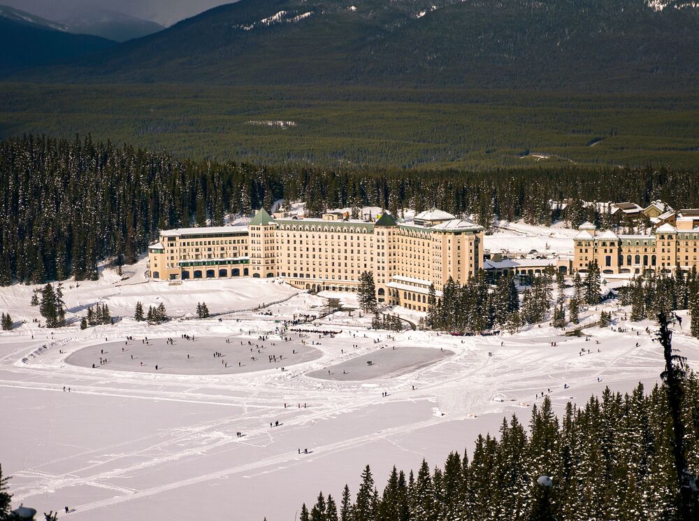 The Fairmont Chateau Lake Louise with two skating rinks as seen from Fairview Lookout in Lake Louise.