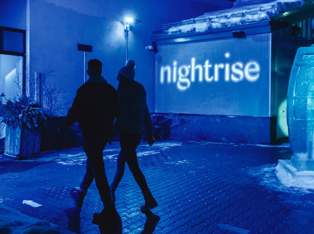 A couple explores the Nightrise Event held at the Banff Gondola in Banff National Park