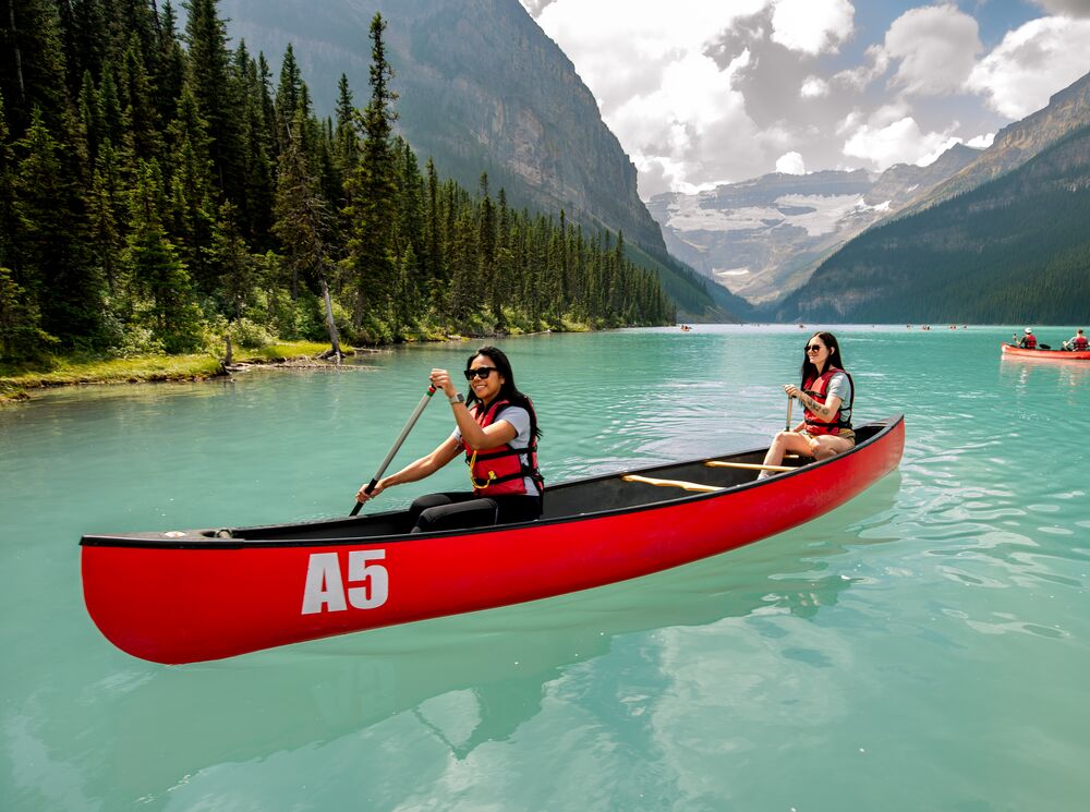 Two people canoeing on the turquoise waters of Lake Louise in Banff National Park.