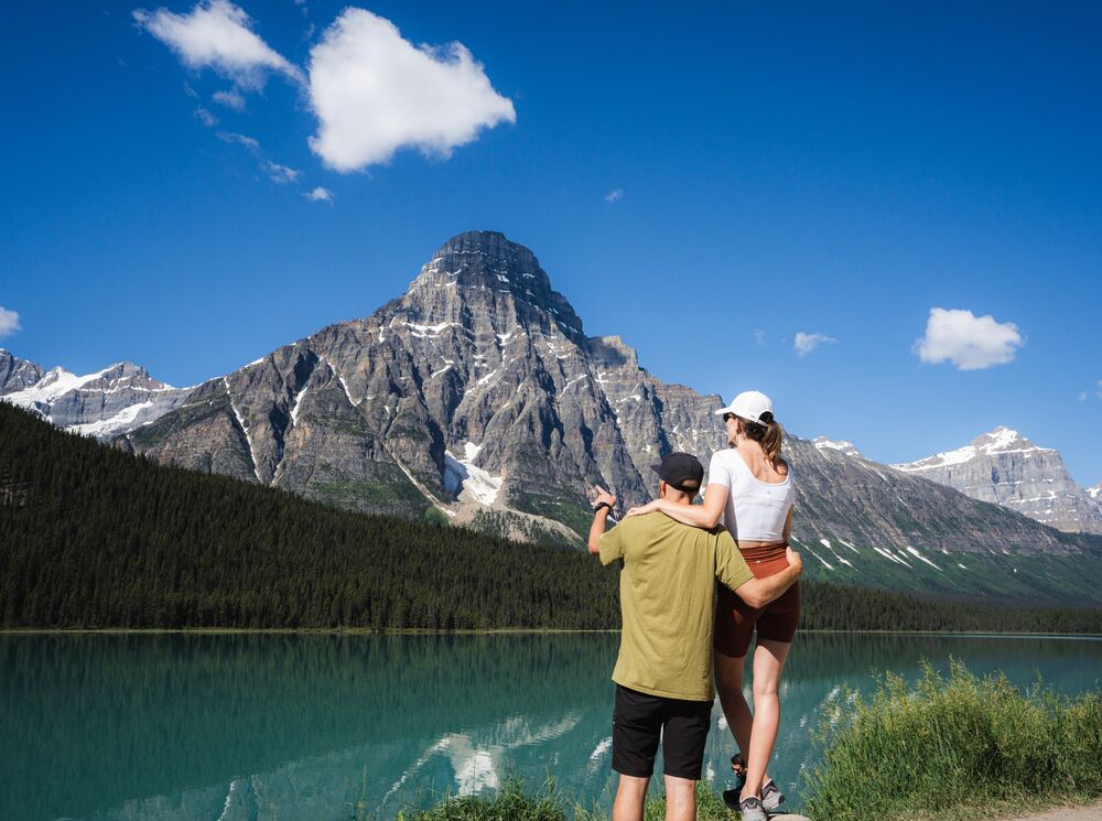 Two people look out at Waterfowl Lake in Banff National Park.