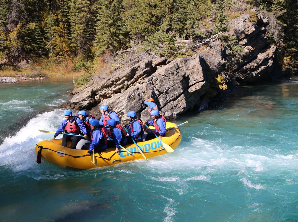 Group of people white water rafting on the turquoise Kananaskis River
