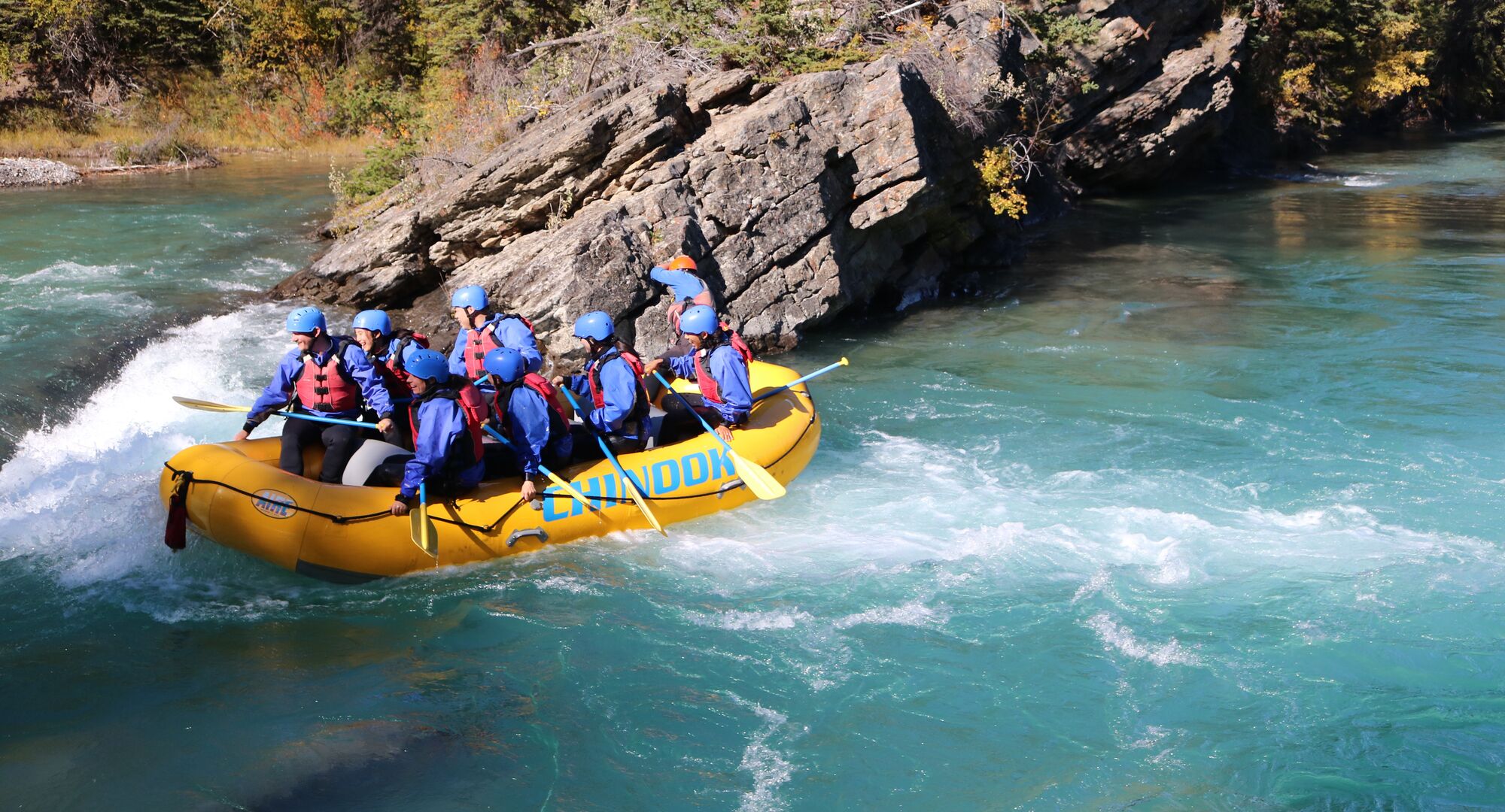Group of people white water rafting on the turquoise Kananaskis River