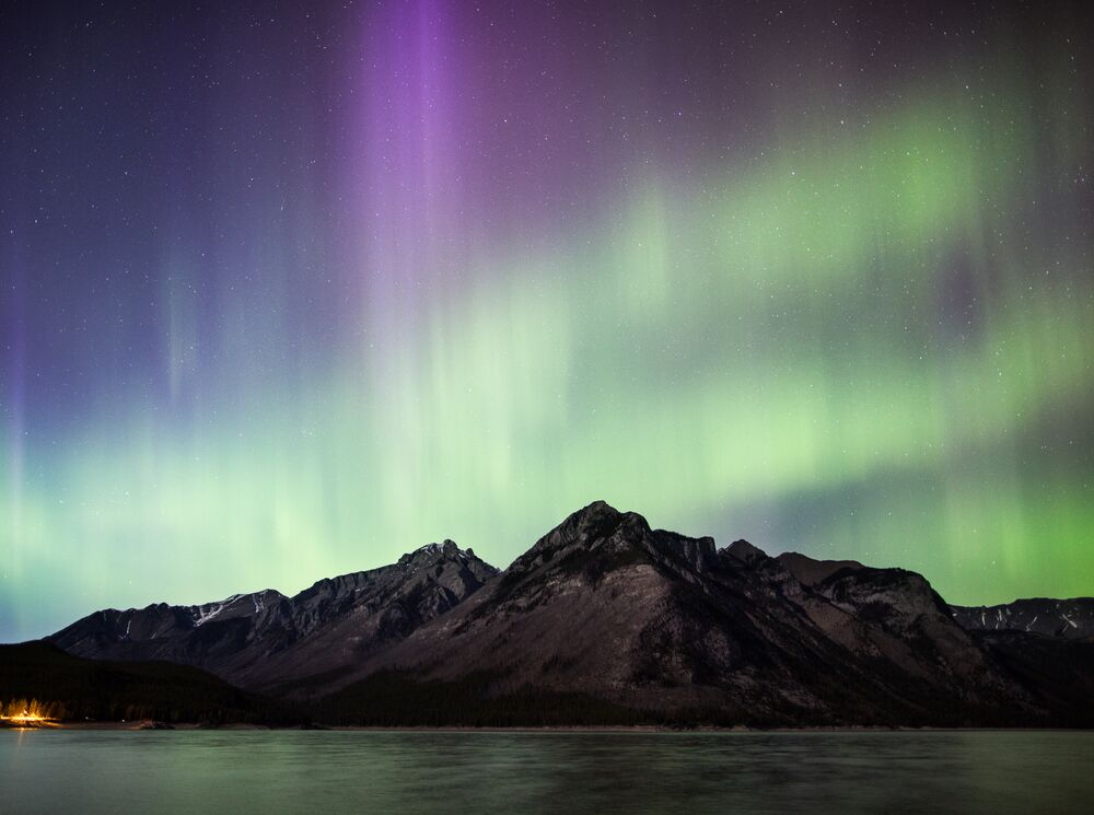 Northern lights over the mountains and Lake Minnewanka in Banff National Park