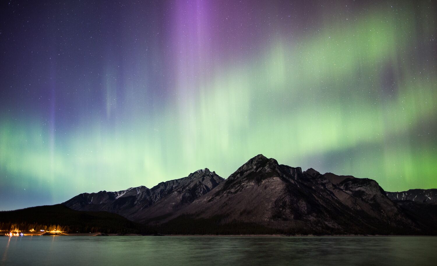 Northern lights over the mountains and Lake Minnewanka in Banff National Park