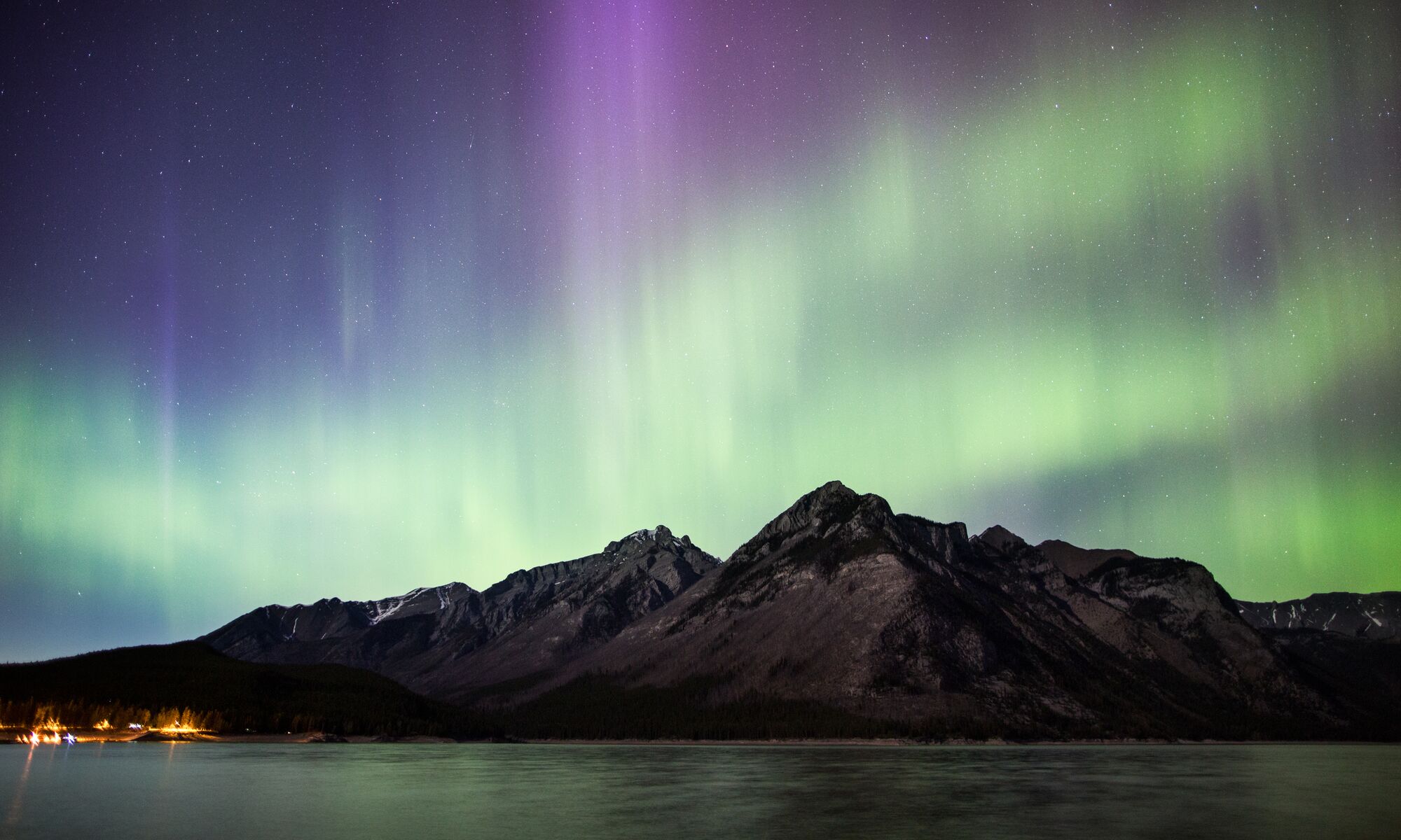 Northern lights over the mountains and Lake Minnewanka in Banff National Park