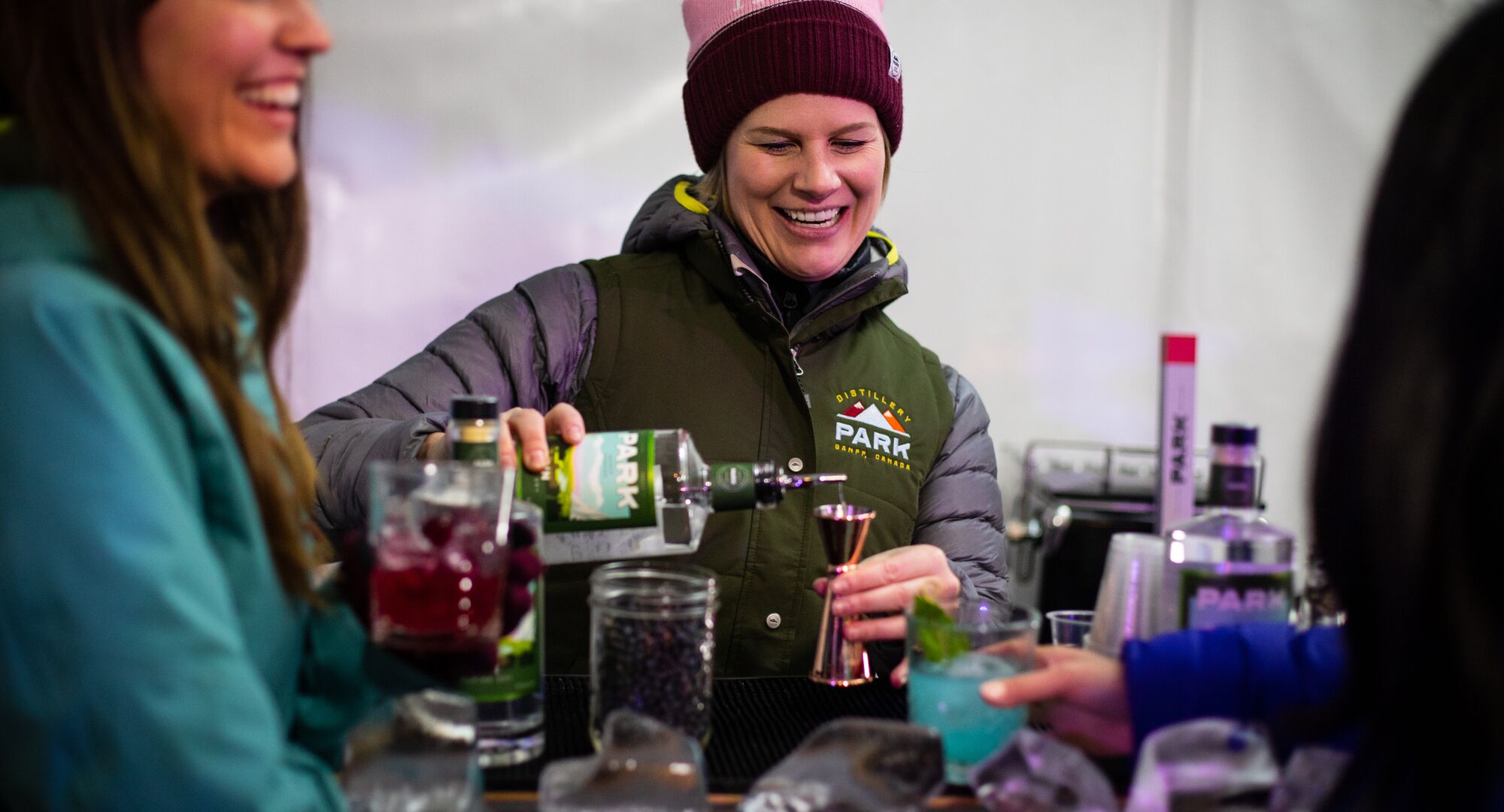 A woman pours a cocktail on Bear Street during an outdoor cocktail festival.