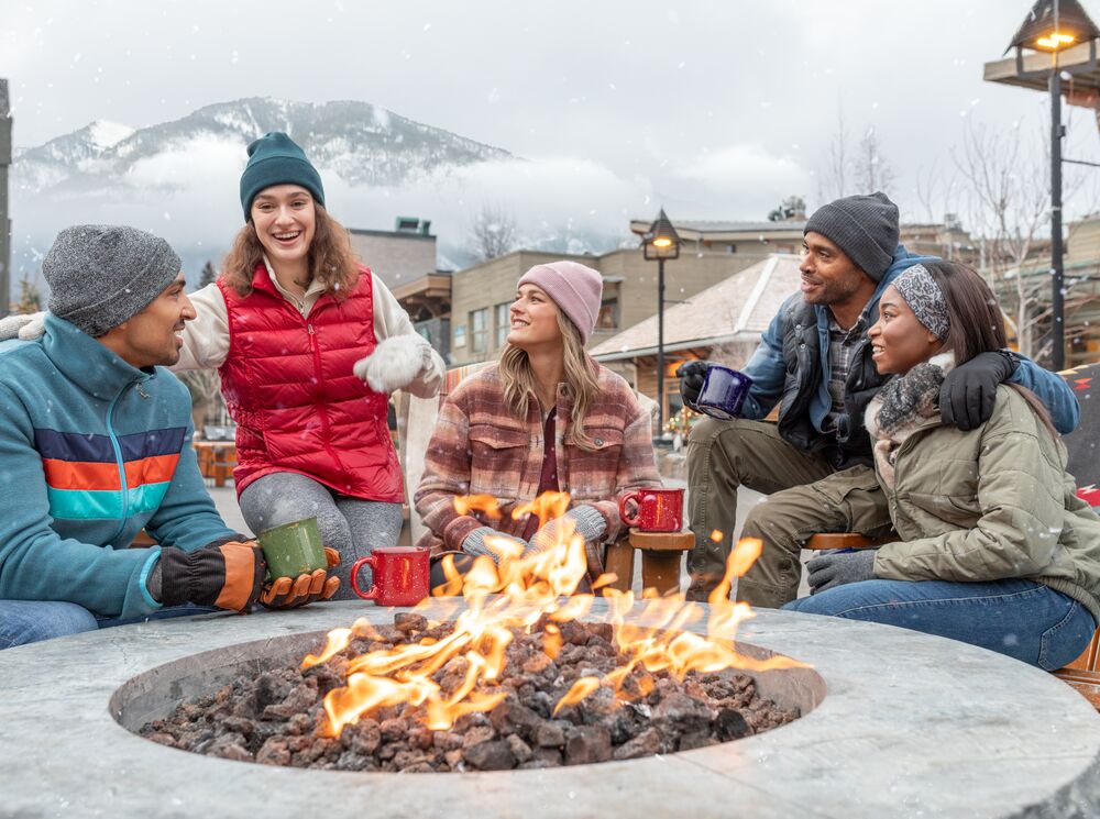 A group of Friends sit around the fire on Bear Street in Banff 