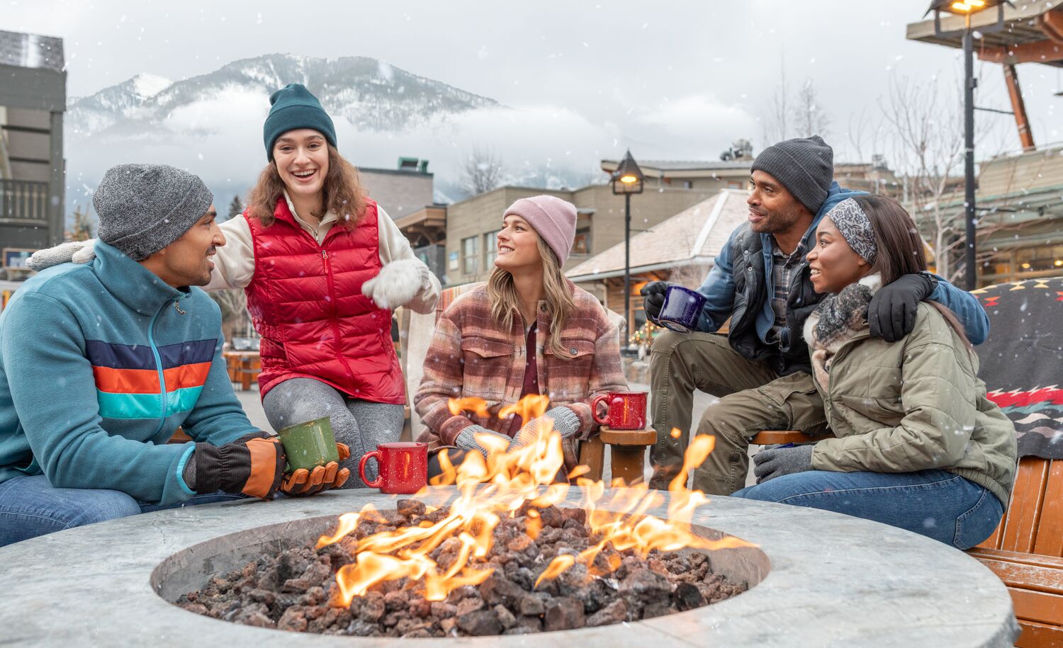A group of Friends sit around the fire on Bear Street in Banff 