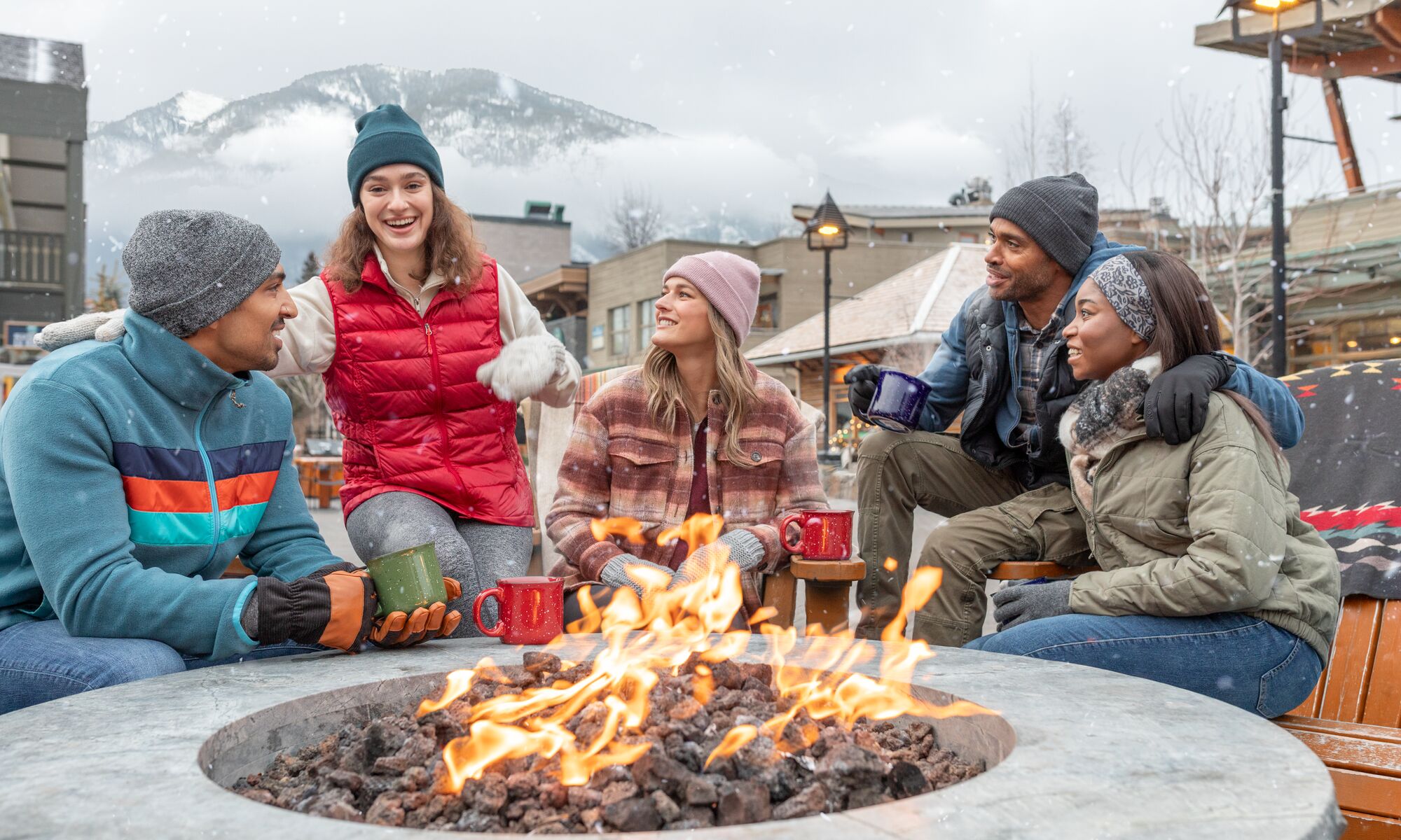 A group of Friends sit around the fire on Bear Street in Banff 