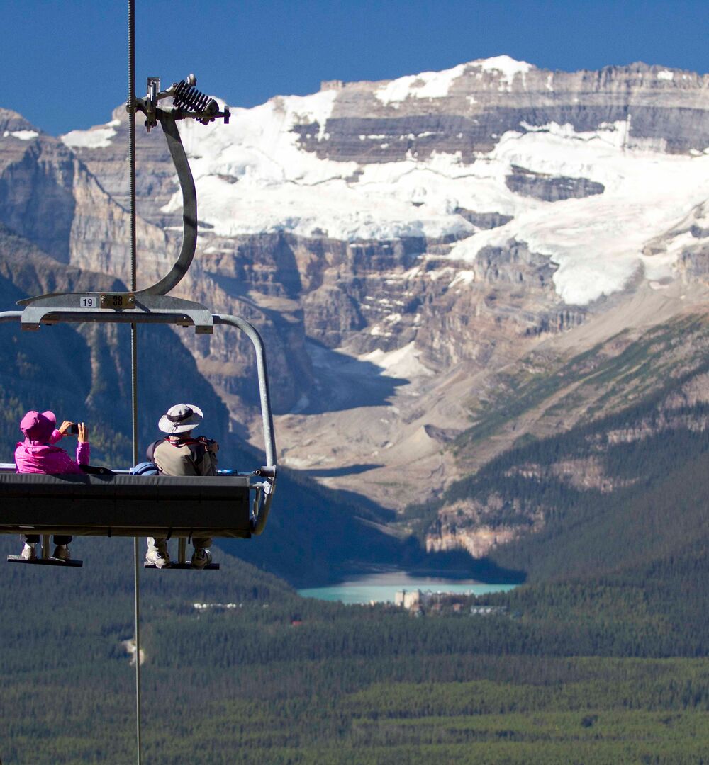 A couple rides the the chairlift at the Lake Louise Sightseeing Gondola in Banff National Park.
