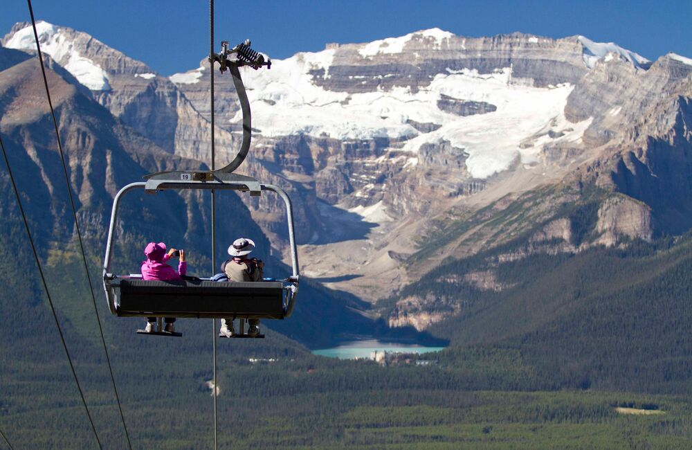 A couple rides the the chairlift at the Lake Louise Sightseeing Gondola in Banff National Park.