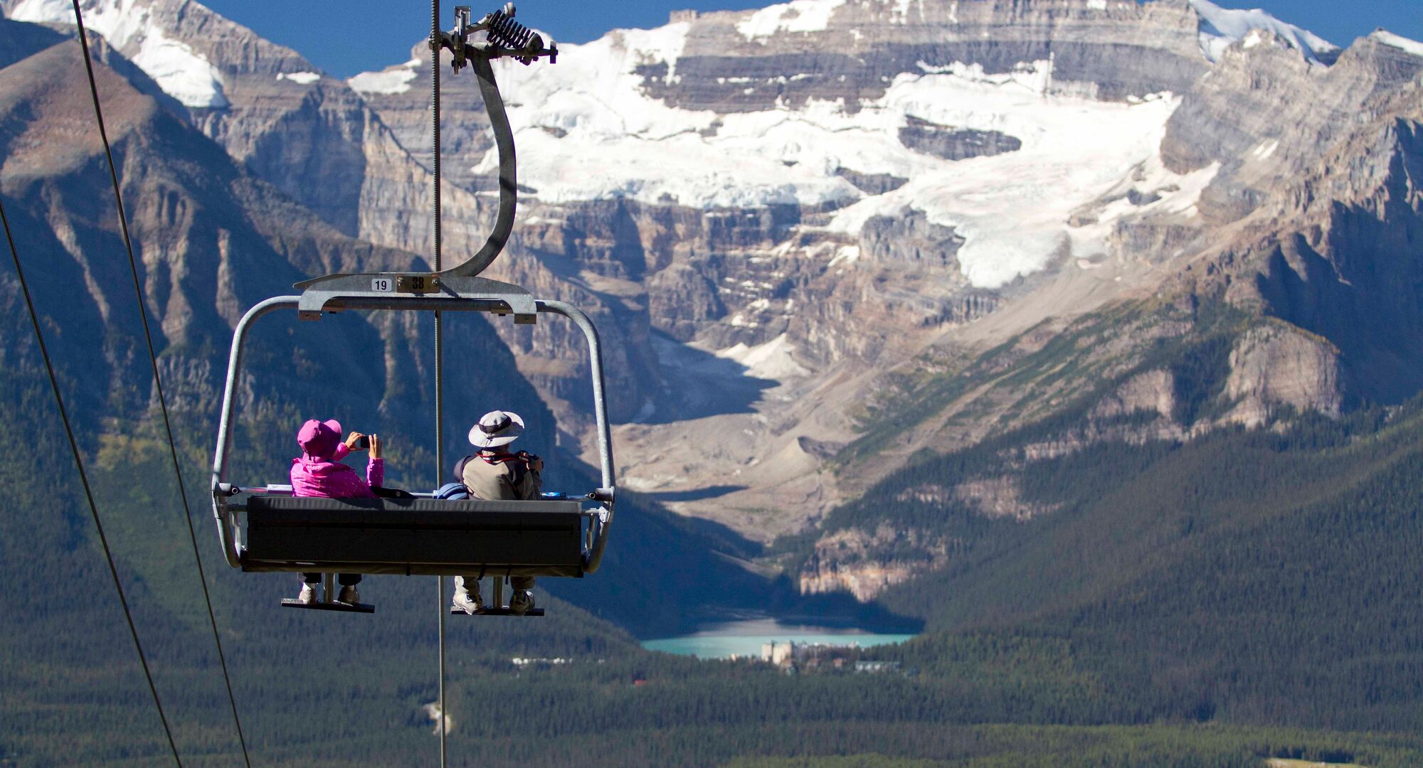 A couple rides the the chairlift at the Lake Louise Sightseeing Gondola in Banff National Park.