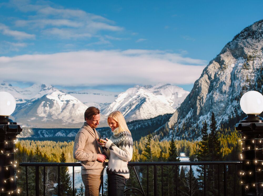 Two people getting engaged at Rundle Bar at the Fairmont Banff Springs.