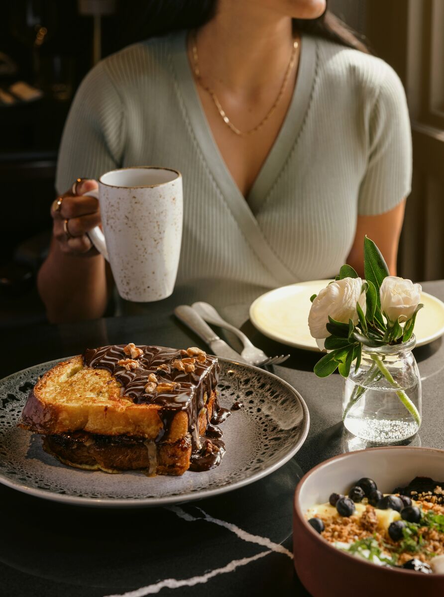A woman enjoys a hot drink and a meal at Brazen in Banff.