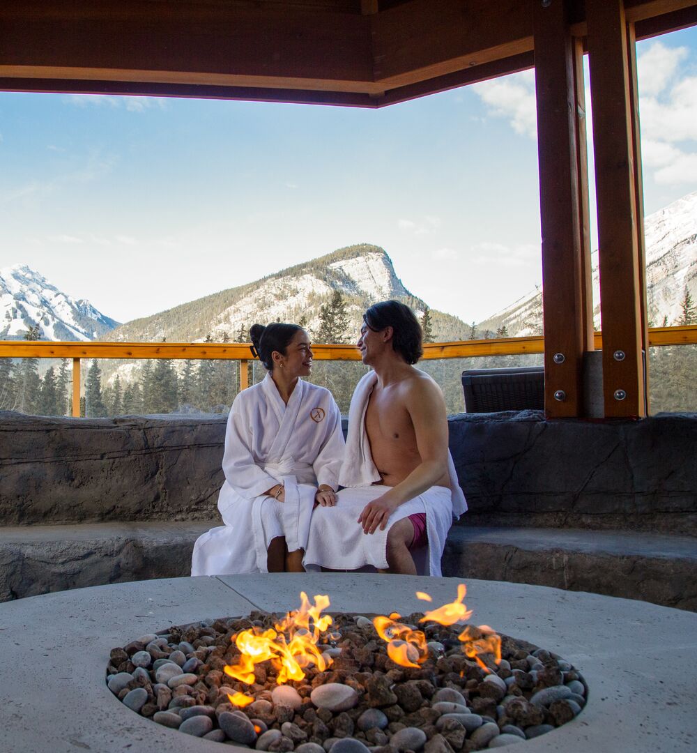Two people at a spa outdoors at the Canoe Hotel in Banff