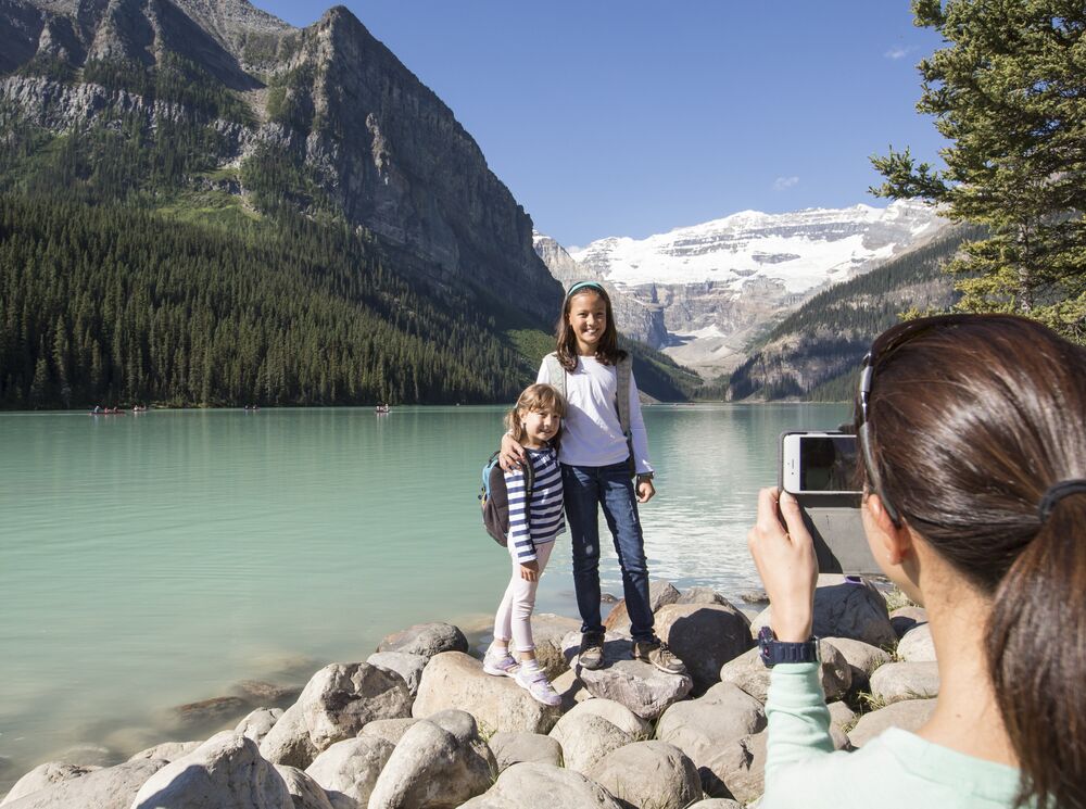 Two kids pose for a photo on the Lake Louise lakeshore trail in Banff National Park.