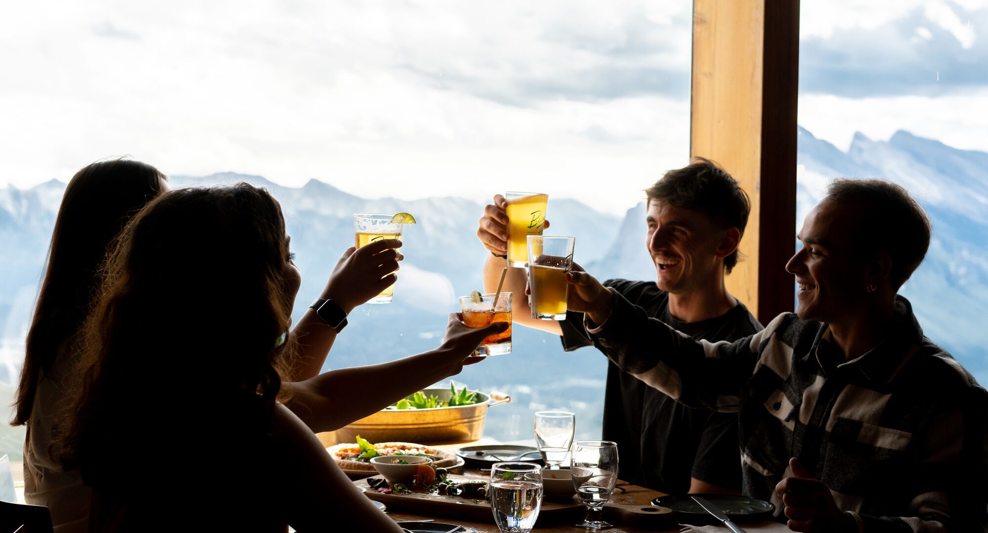 Group of four cheersing in front of the mountain views