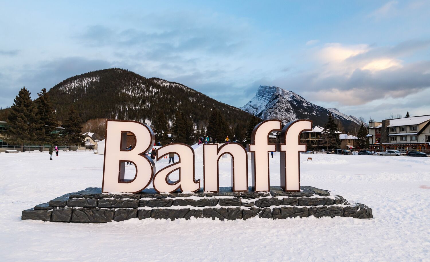 バンフ国立公園のバンフ タウンサイトにある、サルファー山とランドル山が描かれたライトアップされたバンフの標識。