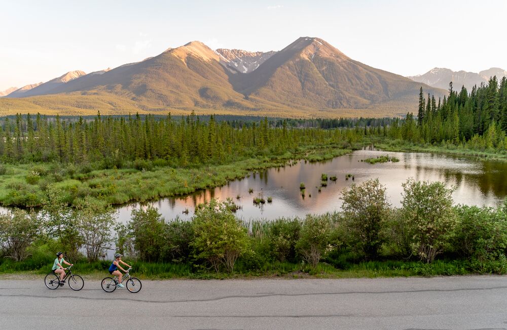 A couple of friends biking along the Vermilion Lakes in Banff National Park