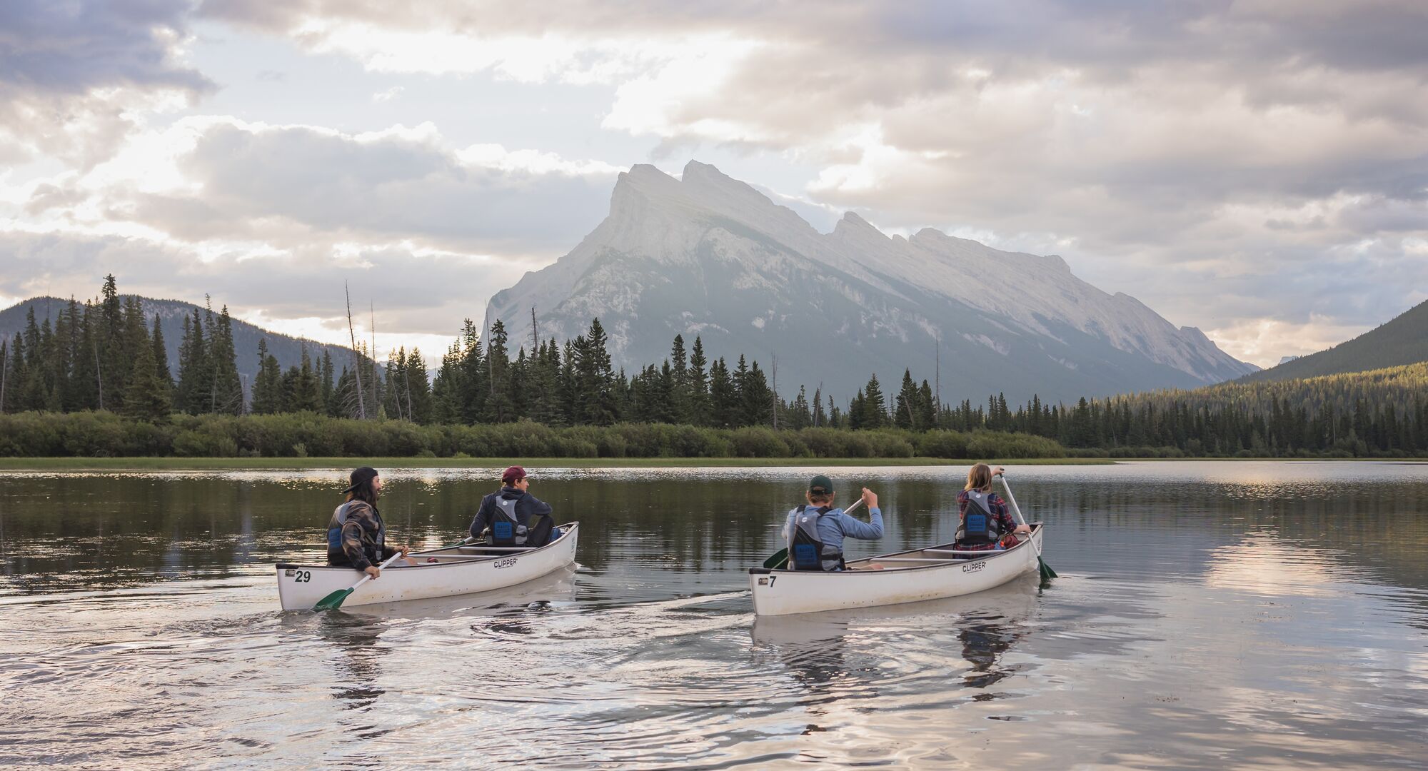 Banff Canoe Club canoeing at sunrise or sunset on Vermilion Lakes near Banff town.