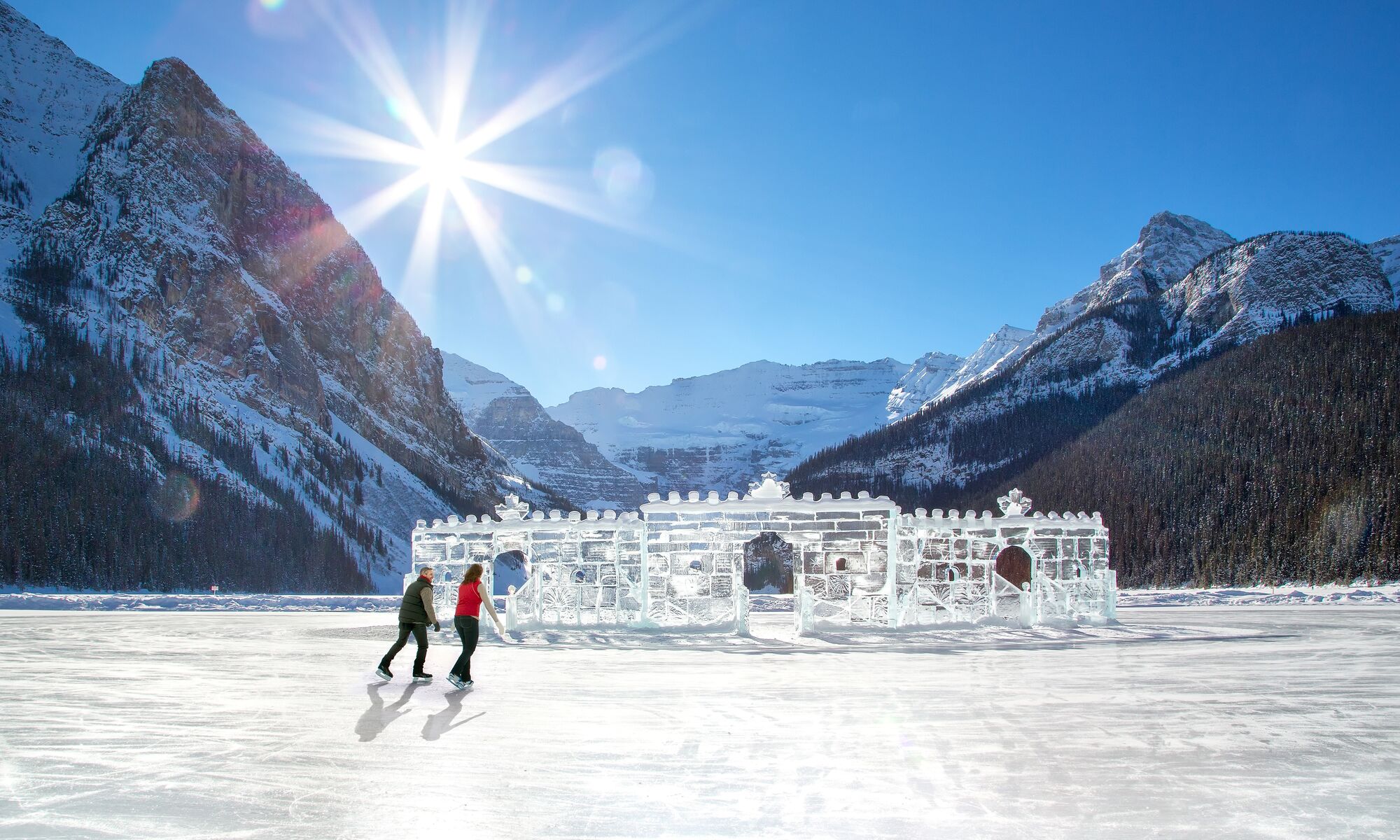 A couple skates by the ice castle on Lake Louise in Banff National Park.