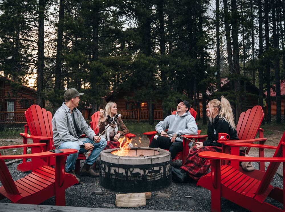 Friends hang out by the fire pit at Baker Creek by Basecamp Resorts
