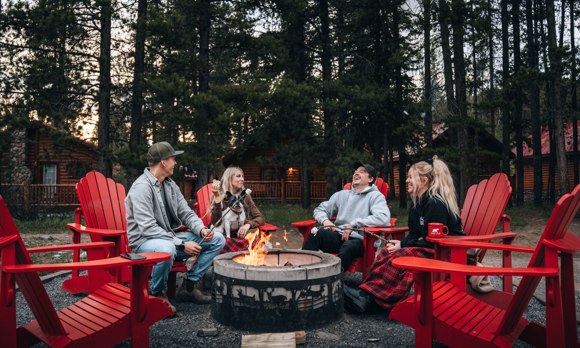 Friends hang out by the fire pit at Baker Creek by Basecamp Resorts