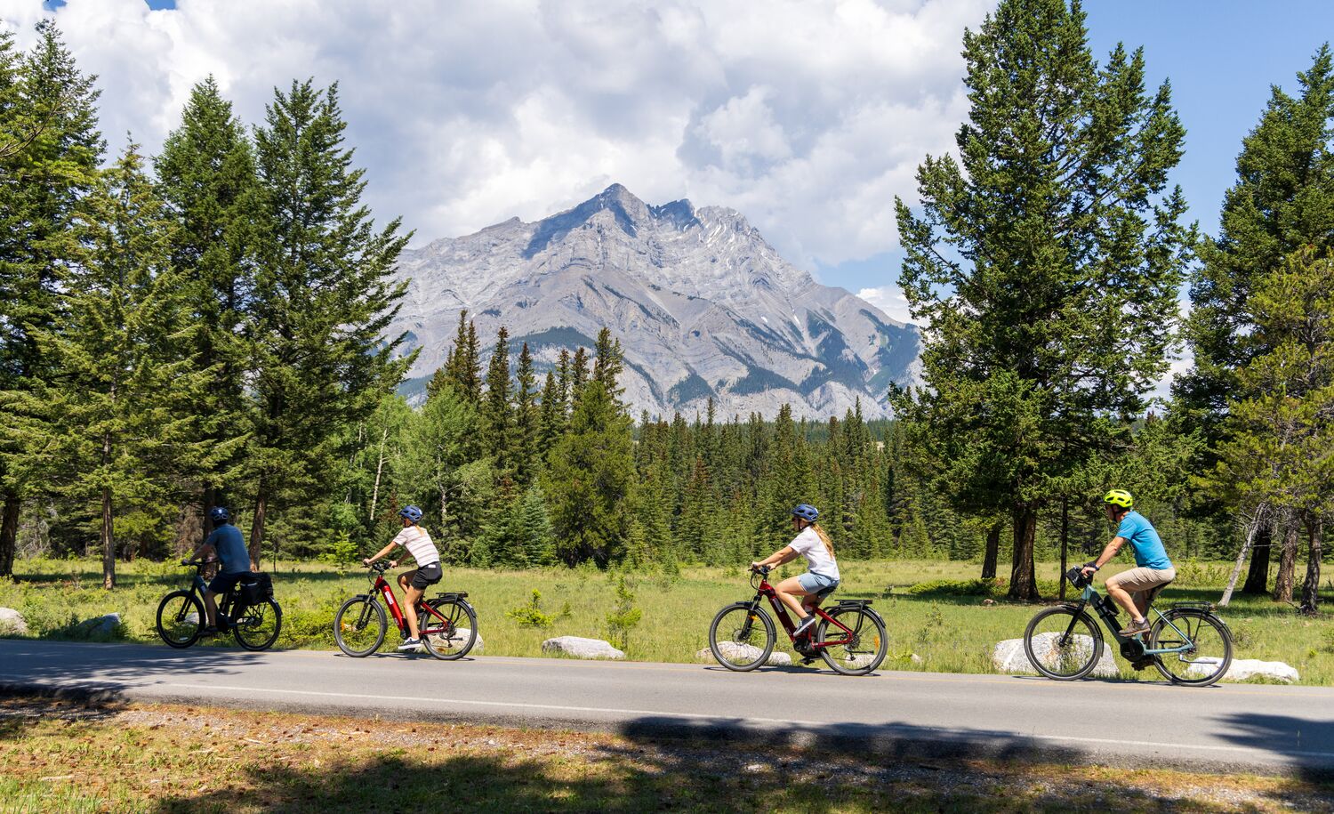 Four people biking along the golf course road, one of the most popular things to do in Banff National Park in June
