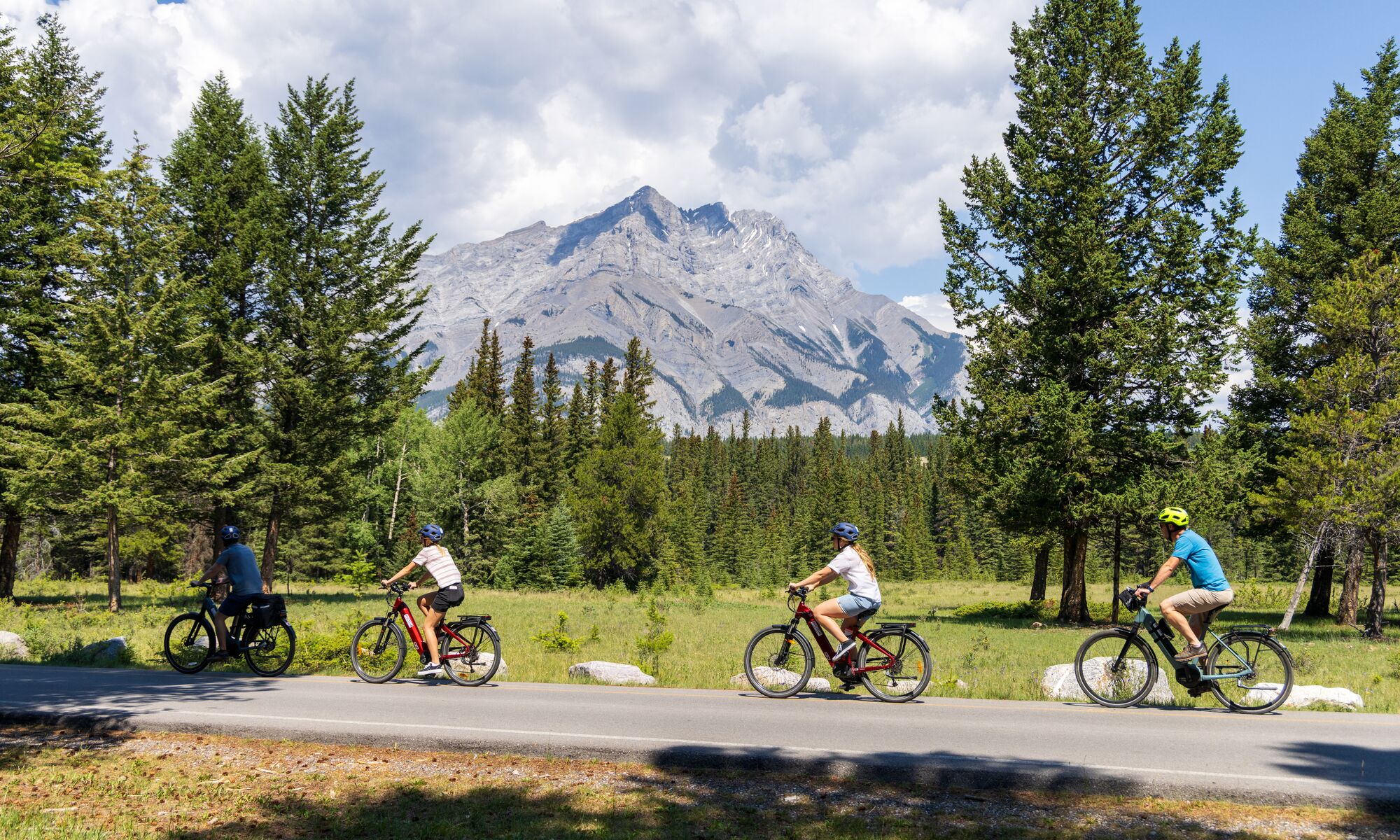 Four people biking along the golf course road, one of the most popular things to do in Banff National Park in June