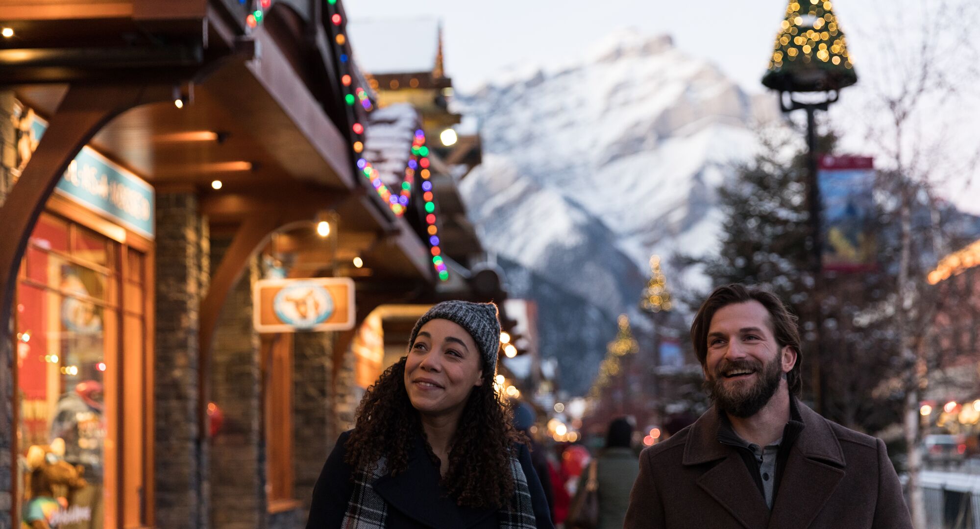 Two people walk down Banff Ave doing their Christmas and holiday shopping in Banff and Lake Louise.
