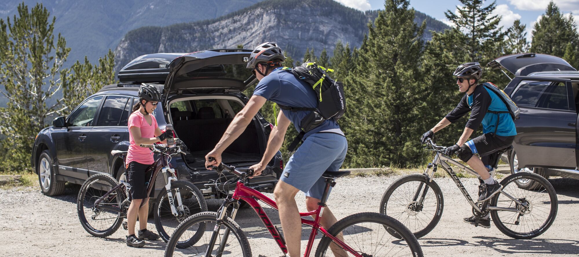 Group of mountain bikers gathered in parking lot with their bikes Tunnel Mountain