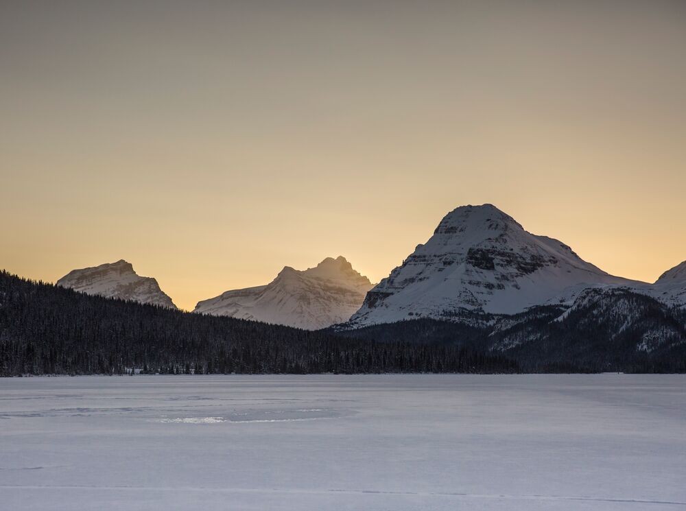 Bow Lake at sunset in the winter, looking towards three big mountains.