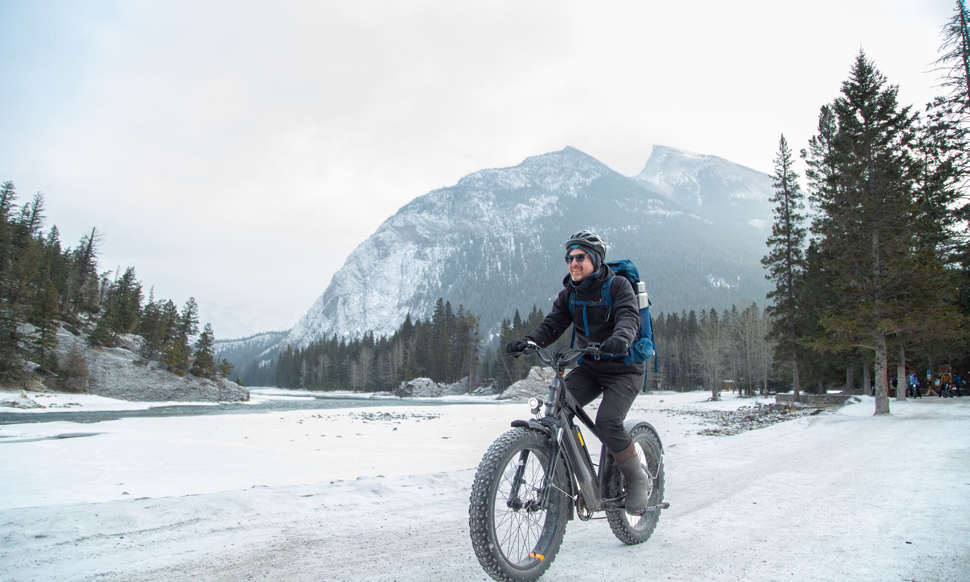 A person fat bikes on a trail near Bow Falls in the winter in Banff National Park