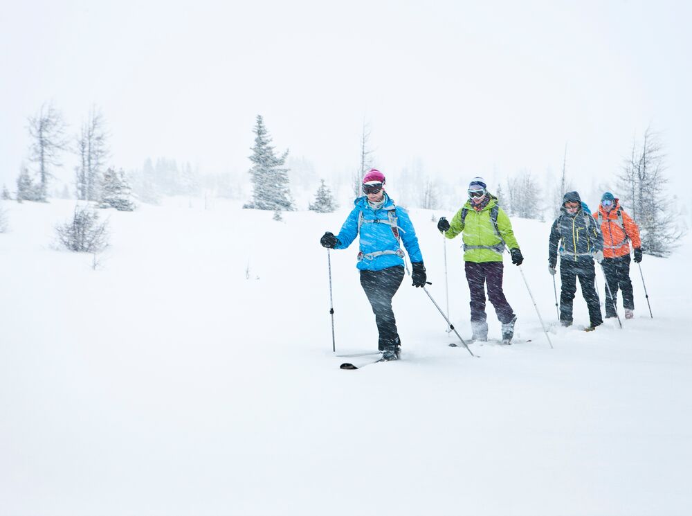 A group of people go ski touring in a blizzard in Banff National Park.