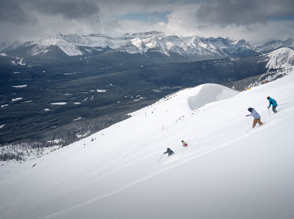 Skiers and snowboarders head down the West Bowl at Lake Louise Ski Resort in Banff National Park