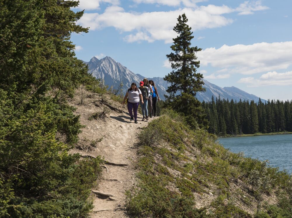 Group of friends hiking the trail around Johnson Lake in the summer