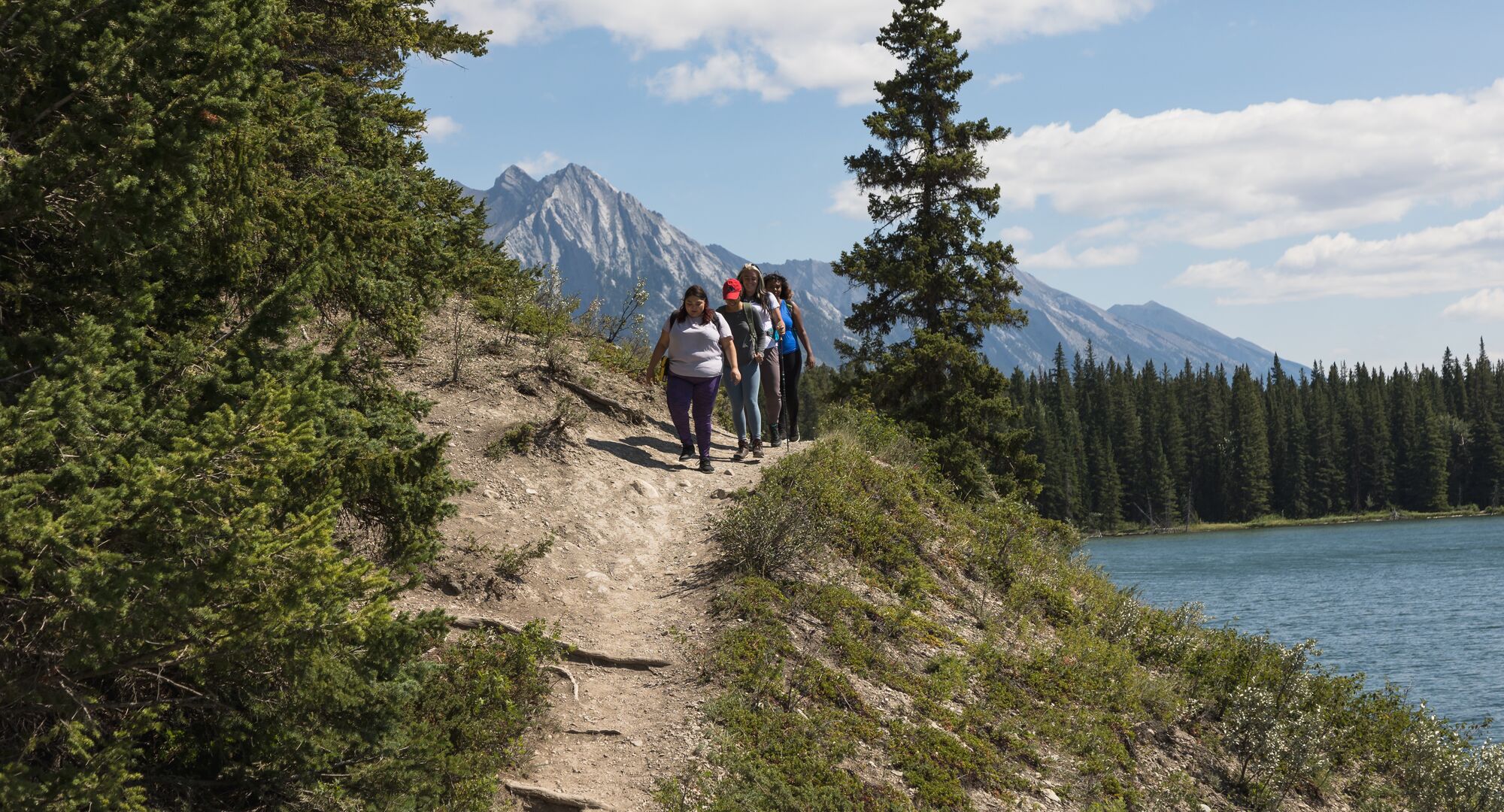 Group of friends hiking the trail around Johnson Lake in the summer